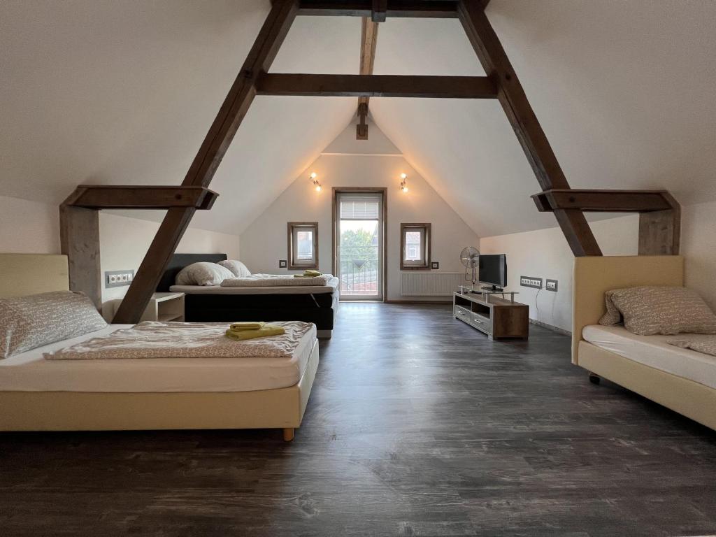 a attic bedroom with two beds and a tv at Dill Apartments Gadenstedt in Ilsede