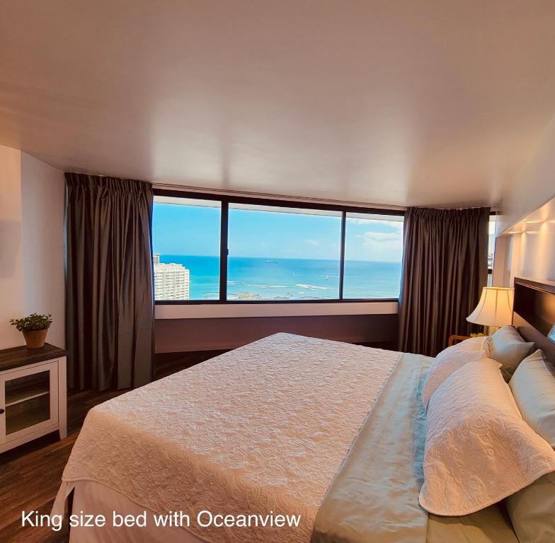 a bedroom with a large bed with a view of the ocean at Waikiki High-rise sea view free parking in Honolulu