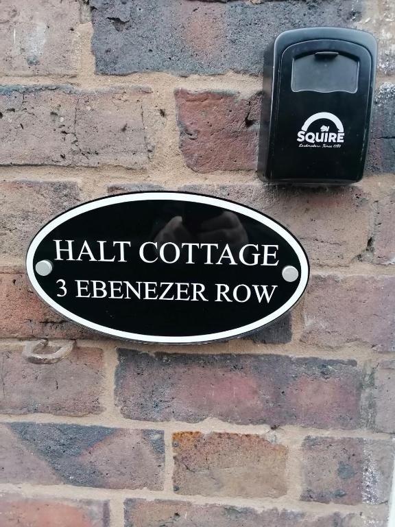 a sign on the side of a brick wall at Halt Cottage in Bridgnorth