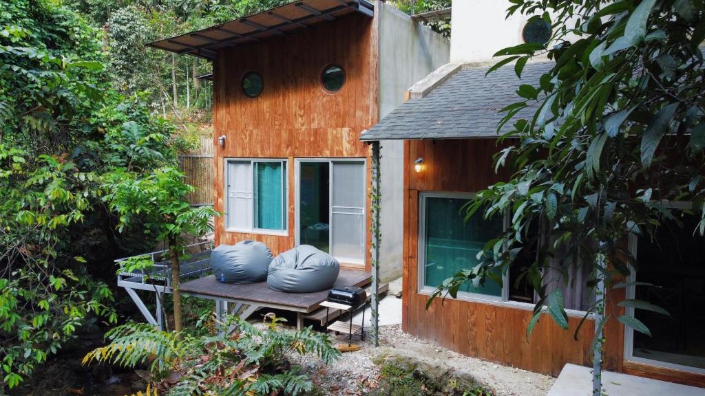 una casa pequeña con almohadas azules sentadas en un banco en Greenspace Living, en Ban Tha Phae