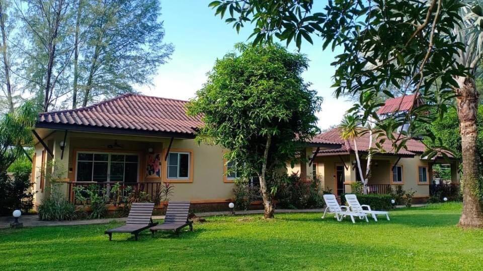 a group of chairs in the yard of a house at Sweet Mango Khaolak in Khao Lak