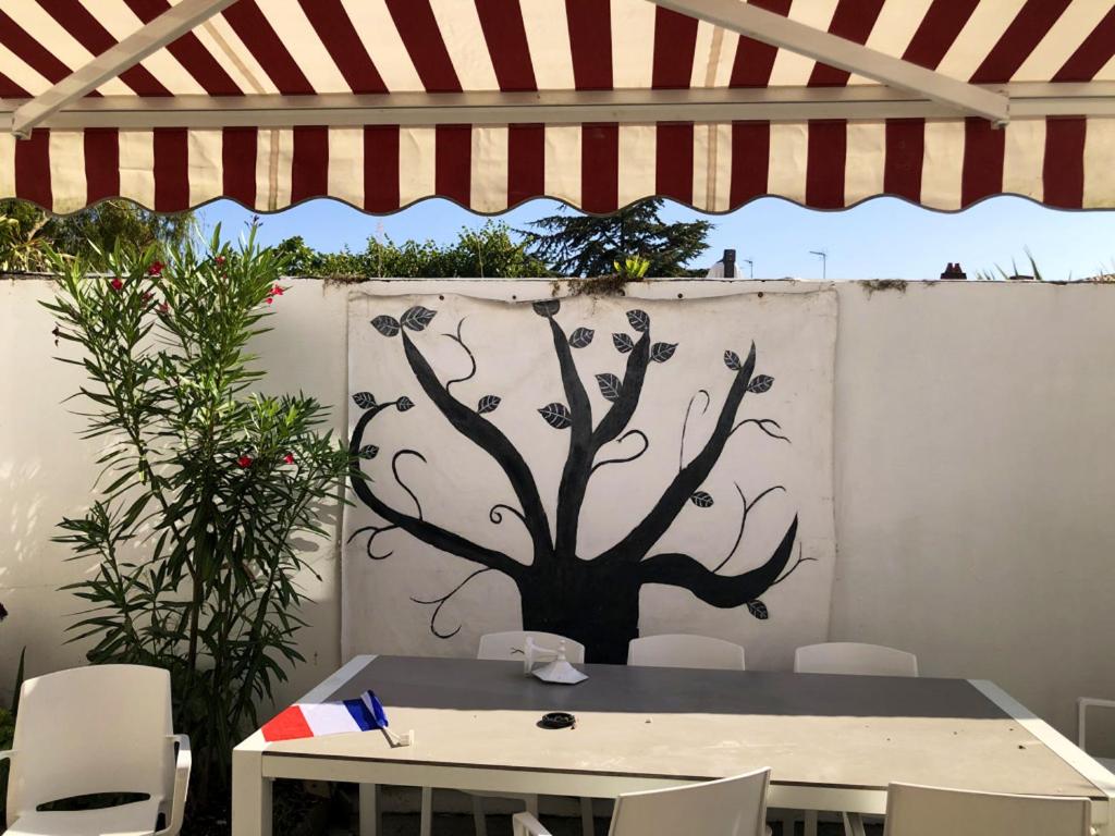 a table with a tree painted on a wall at Appartement de 3 chambres a Les Sables d&#39;Olonne a 800 m de la plage avec wifi in Les Sables-d&#39;Olonne