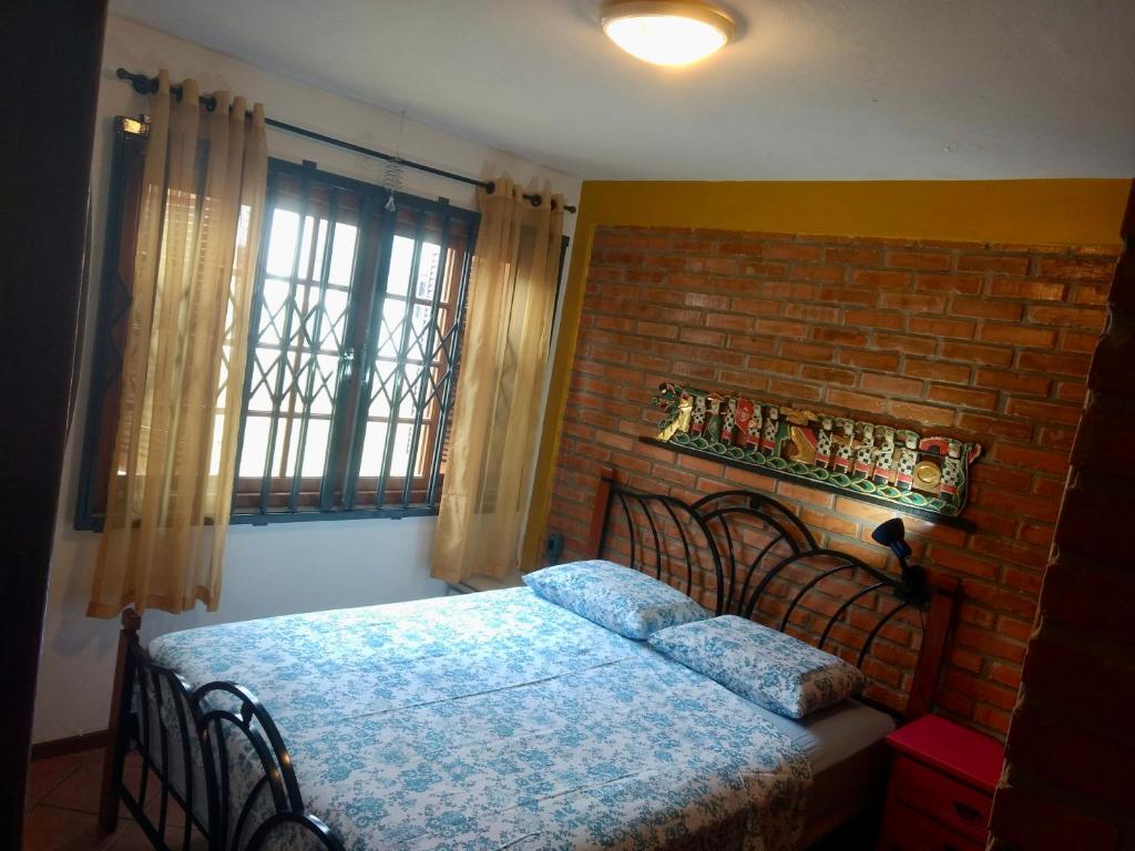 1 dormitorio con cama y pared de ladrillo en Lagoa Apartment, en Florianópolis