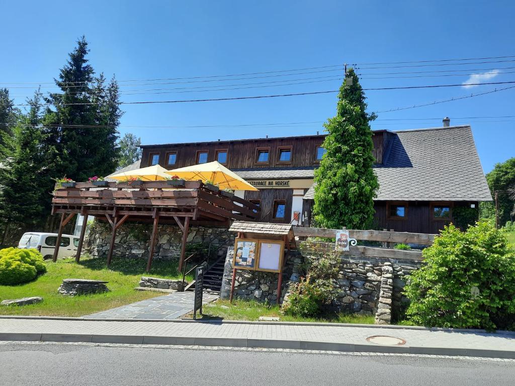 a building with a deck and a house at Chata Resort Na Horské in Malá Morávka