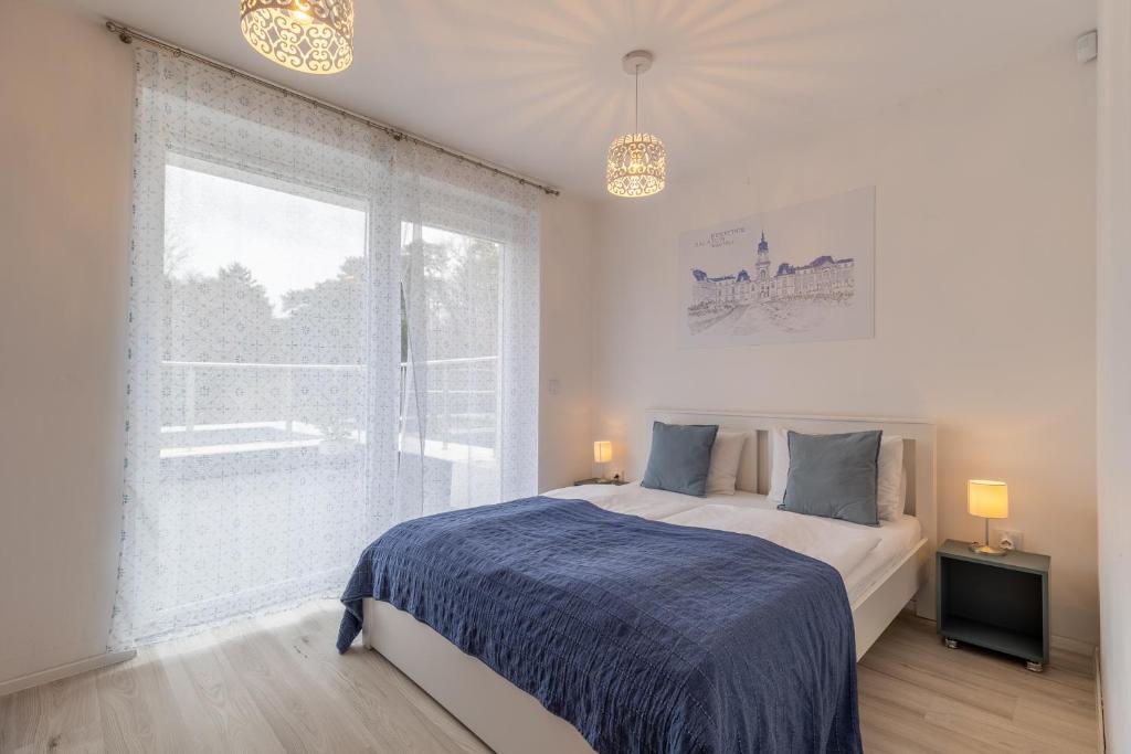 um quarto com uma cama e uma grande janela em Casa Iringo Apartman By BLTN Balatonföldvár em Balatonföldvár