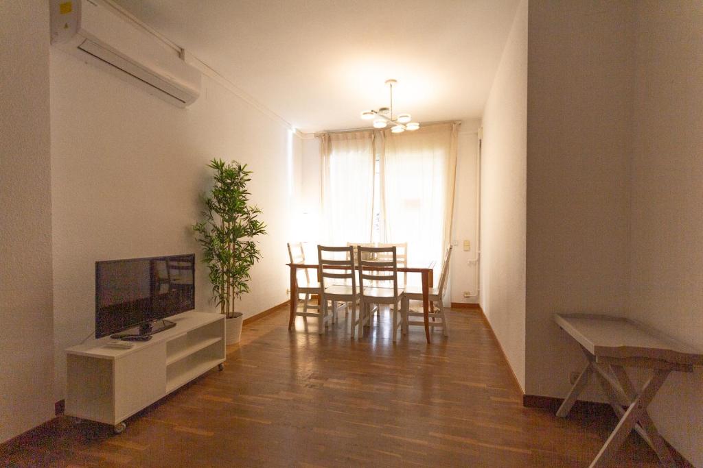 uma sala de estar com uma televisão e uma mesa de jantar em INNOUTHOME Apartamento Eixample Barcelona em Barcelona