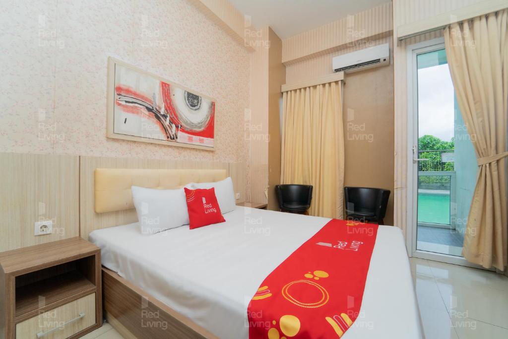 a bedroom with a large bed and a window at RedLiving Apartemen Vivo Yogyakarta - WM Property in Yogyakarta