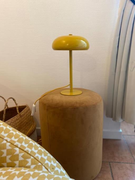a yellow lamp sitting on top of a table at Loft&#47;jardin et parking : Le Petit Clos Bourdet in Honfleur
