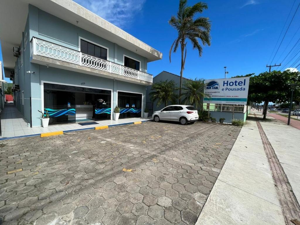 a car parked in a parking lot in front of a hotel at Hotel Pousada Mar Azul in Itapoa