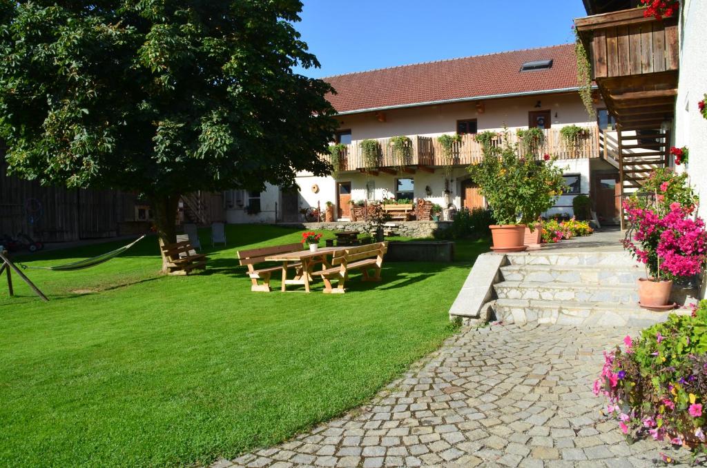 a garden with a picnic table and flowers at Ferienhof Weishäupl in Untergriesbach