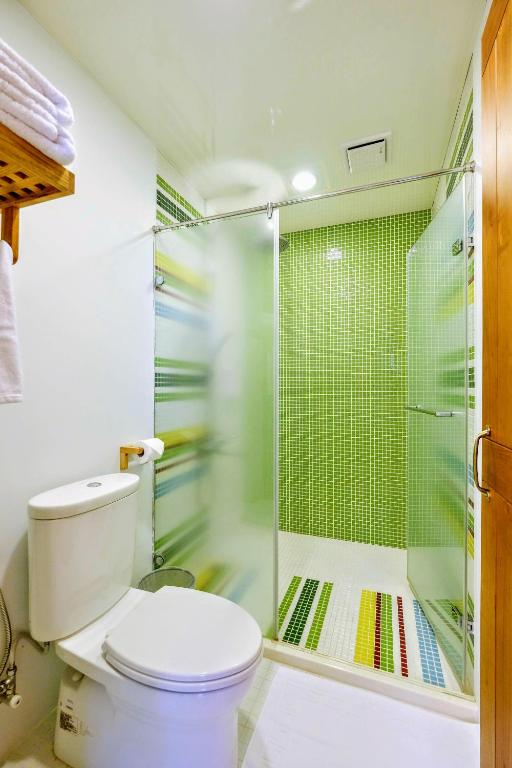 a bathroom with a toilet and a glass shower at Shire Homestay in Luodong