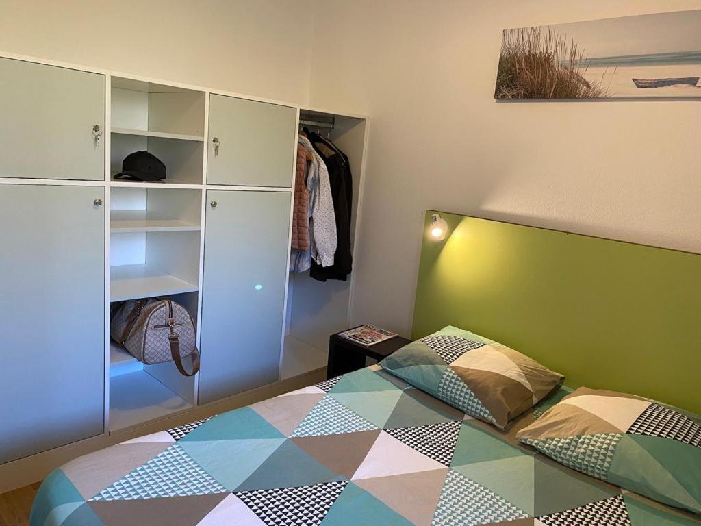 - une chambre avec un lit doté d'une tête de lit verte dans l'établissement Le Maurifleur vous accueille à 3 km de Honfleur, à Équemauville
