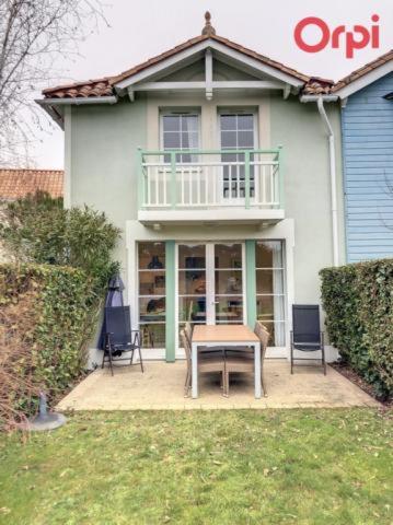 une maison avec une table et des chaises devant dans l'établissement Résidence LE BOCAGE PORT BOURGENAY 85440, à Talmont-Saint-Hilaire