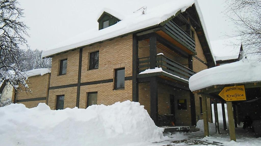 un edificio ricoperto di neve con un mucchio di neve di Guesthouse Kraljica a Kolašin