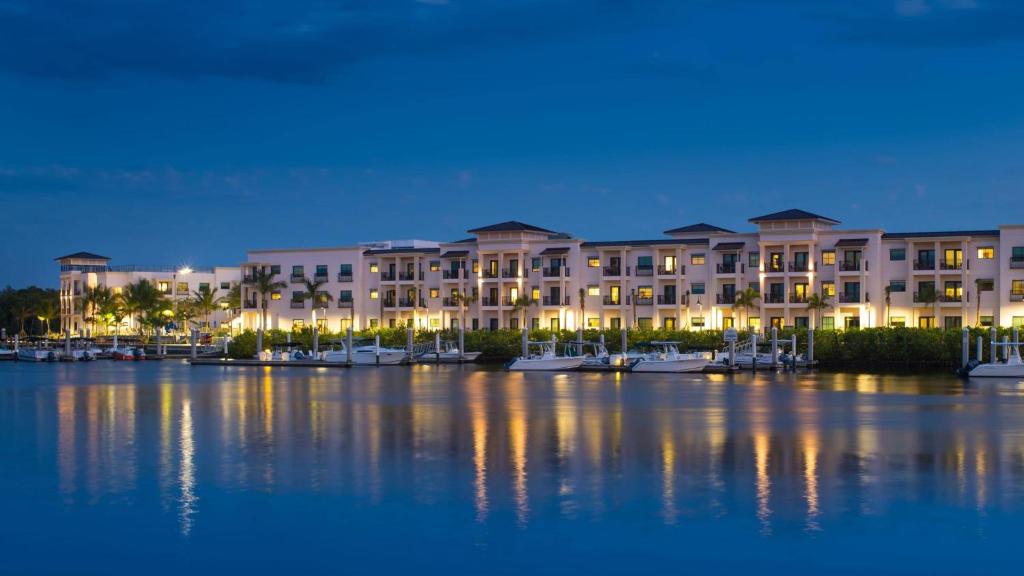 a large building with boats in a marina at night at Hyatt House Naples 5th Avenue in Naples