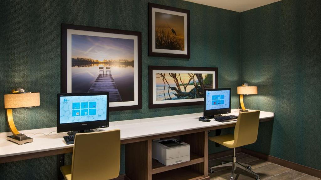 a office with two computers on a desk with two chairs at Hyatt House Naples 5th Avenue in Naples
