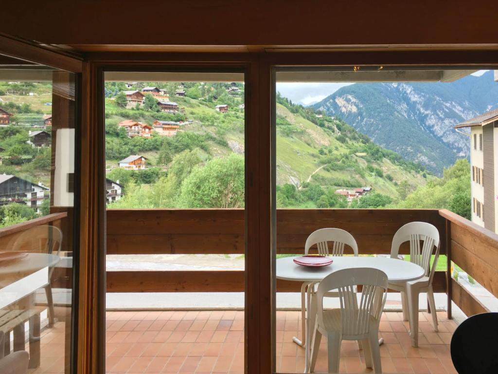 d'une table et de chaises sur un balcon avec vue. dans l'établissement Appartement à 200m de la télé-cabine de Vercorin, à Vercorin