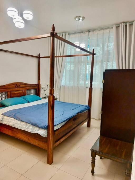 a bedroom with a canopy bed with blue sheets at apartment in Ajman for 4 persons near the sea in Ajman 