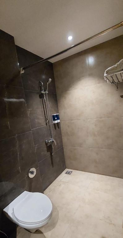 a bathroom with a toilet and a shower at Click Hotel Bhuj in Bhuj