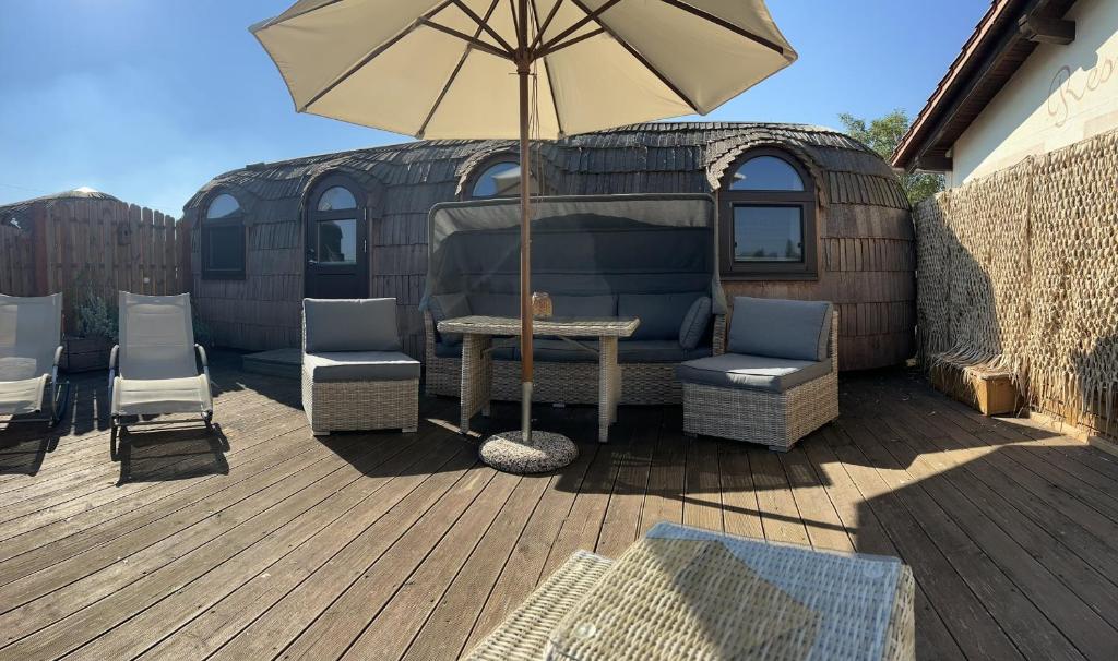 een patio met een tafel en stoelen en een parasol bij Panorama Iglu Romantik & Family in Parey