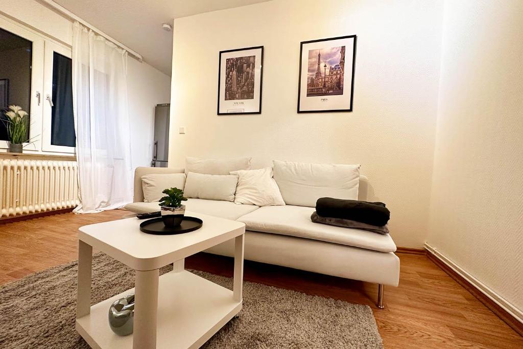 - un salon avec un canapé blanc et une table dans l'établissement Cozy Apartment in Wuppertal, à Wuppertal