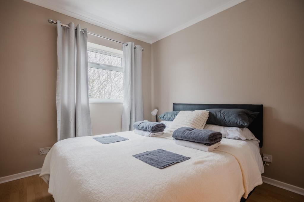a bedroom with a large bed with pillows and a window at Hullidays - Hymers Apartment in Hull