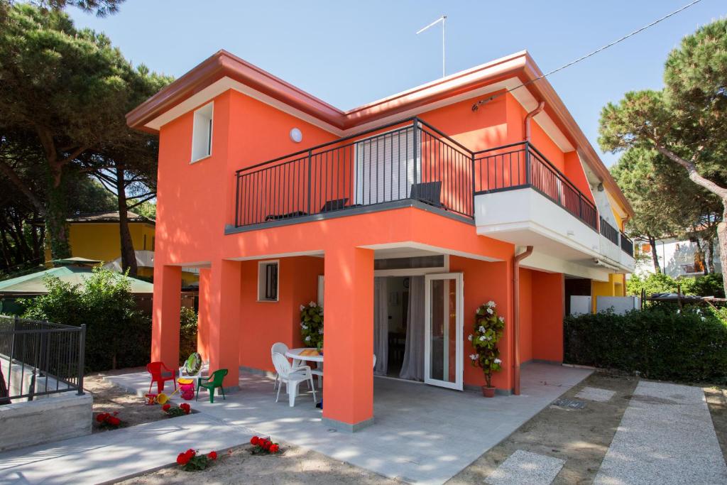 an orange house with a balcony and a table at Principesse in Rosolina Mare