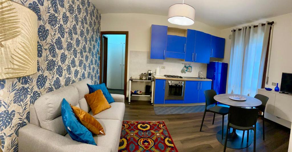 sala de estar con sofá y cocina con armarios azules en Residenza Bella, en Vicenza