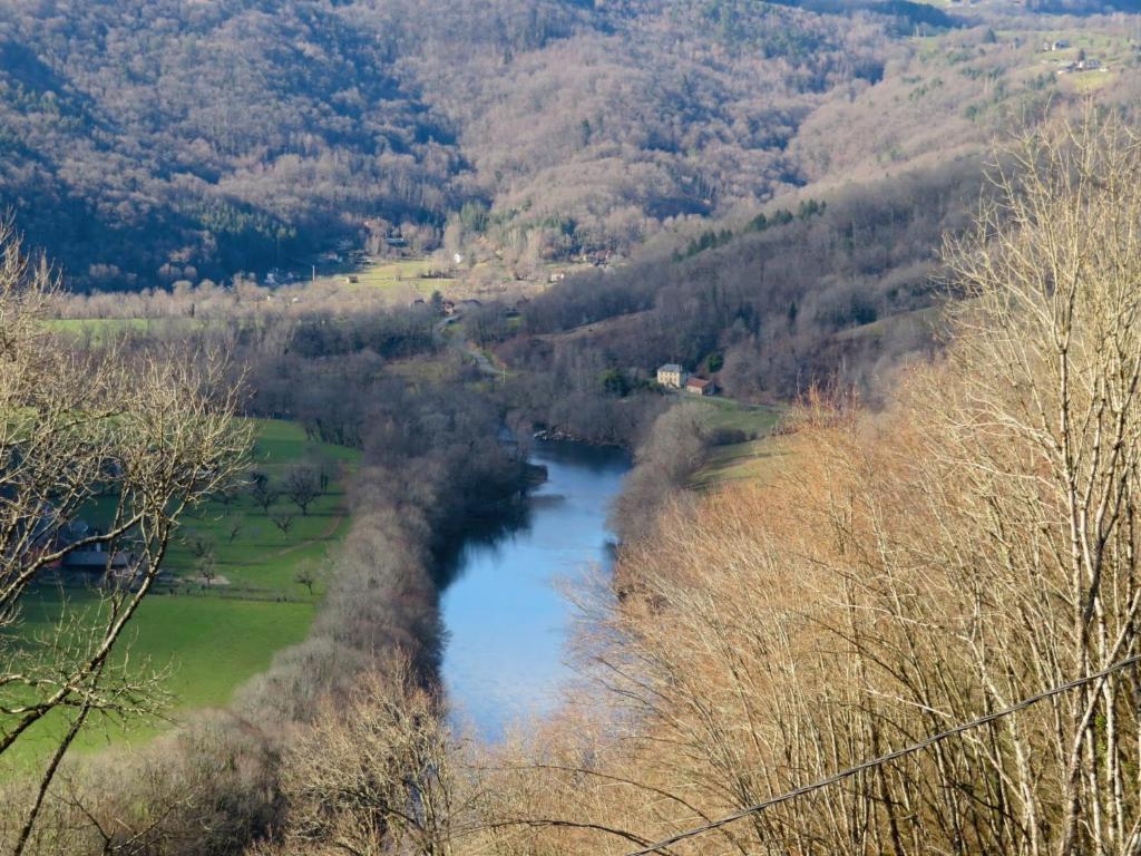 a view of a river in a valley with trees at Château de Chauvac - Chambres et table d'hôtes avec vue sur la rivière in Bassignac-le-Bas