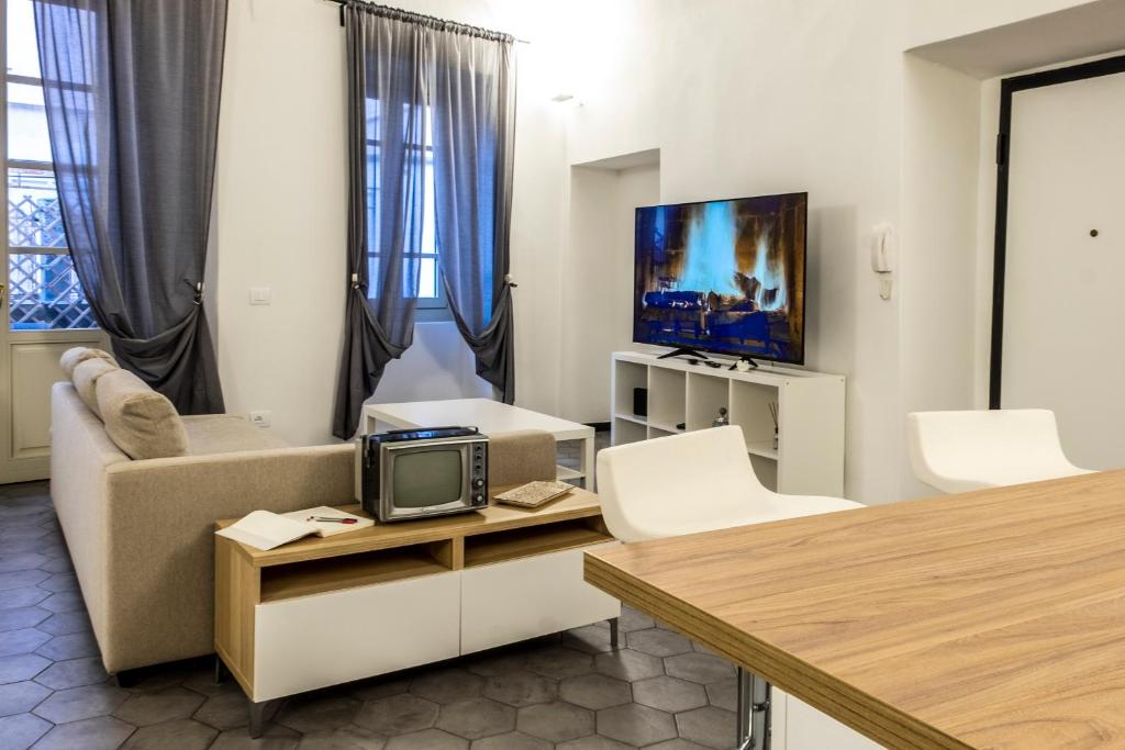 salon z kanapą i telewizorem w obiekcie Affittacamere Archivolto del Teatro w Albendze