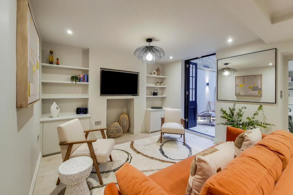 a living room with a couch and a tv at Argyle Apartments, Kings Cross in London