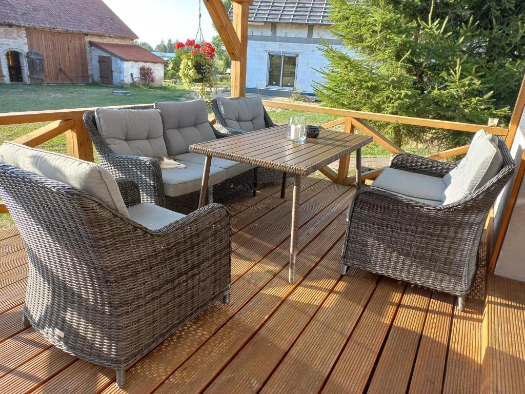 a patio with a table and chairs on a deck at Siedlisko 14 Chata in Mikołajki