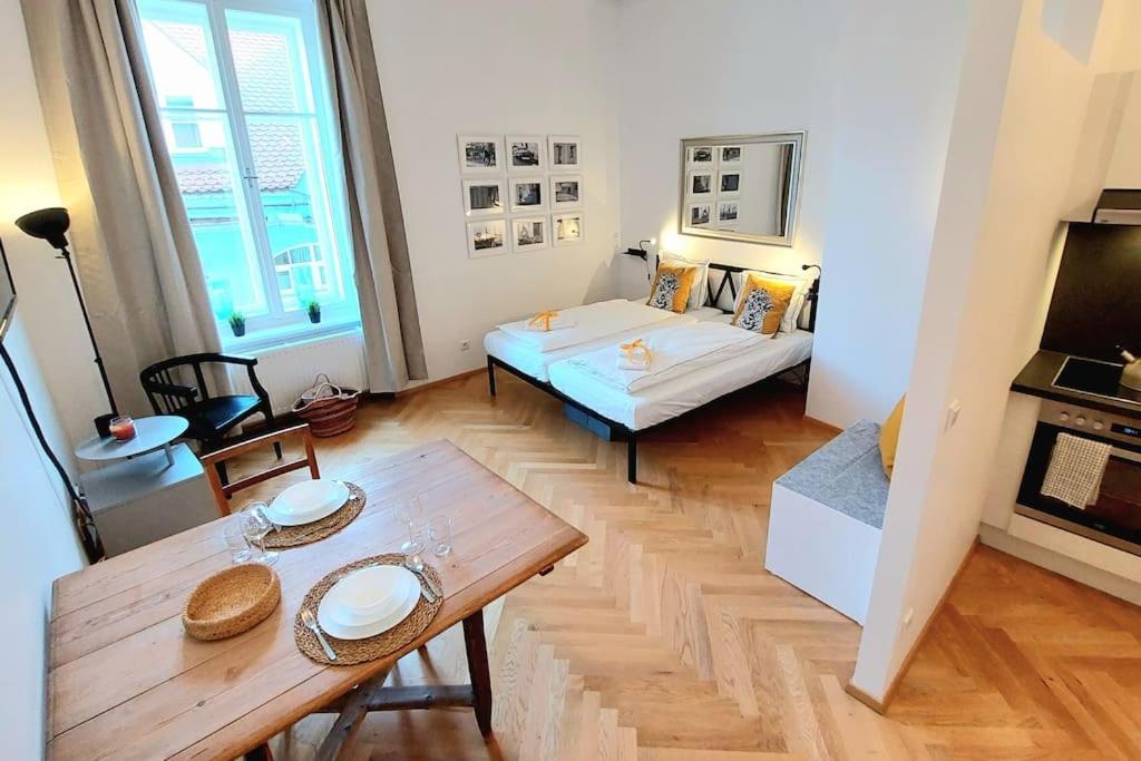a small living room with a table and a bed at Homelystay Graz - downtown app in Graz
