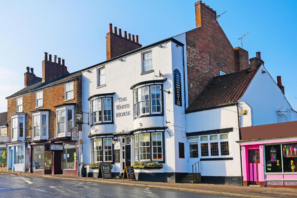 un bâtiment blanc au coin d'une rue dans l'établissement OYO The White Horse, Ripon North Yorkshire, à Ripon