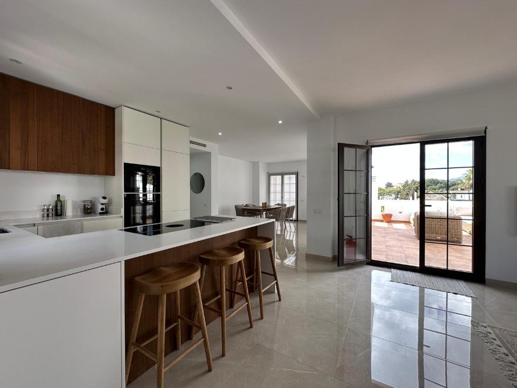 a kitchen with a counter and bar stools at Aldea Blanca Cozy Penthouse in Puerto Banús in Marbella