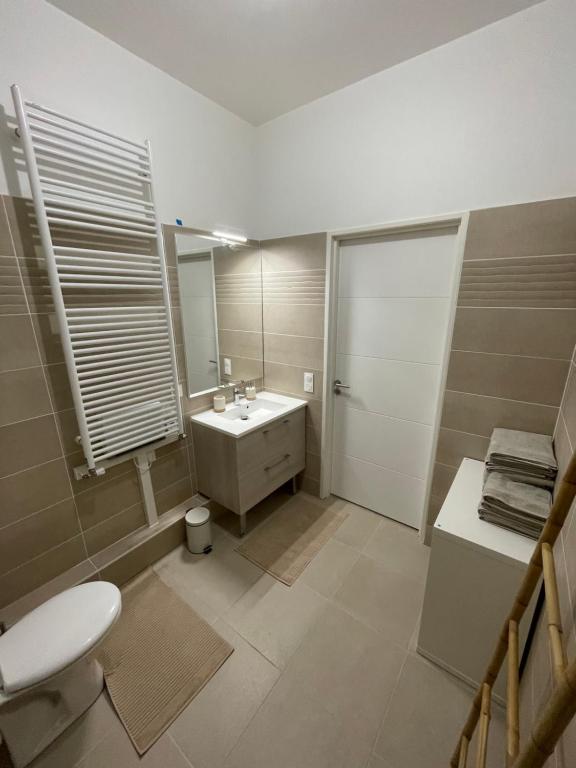 łazienka z umywalką, toaletą i lustrem w obiekcie Nouvel appart bien-être/confort w mieście Saint-Ouen