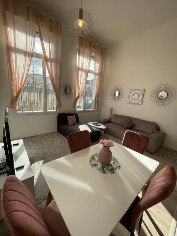 salon z białym stołem i krzesłami w obiekcie Nouvel appart bien-être/confort w mieście Saint-Ouen