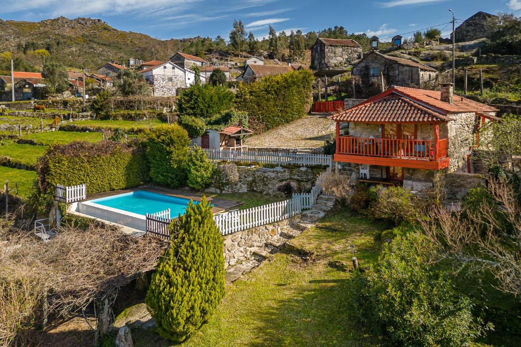 - une vue aérienne sur une maison avec une piscine dans l'établissement GuestReady - Quintinha casas do jardim 2, à Arcos de Valdevez