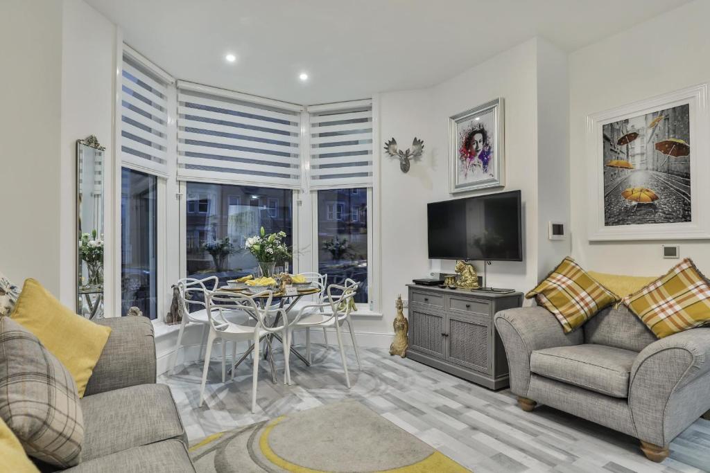 a living room with two couches and a table at The Apartment - Ground Floor - Luxury for up to 4 guests near Open Air Theatre and North Bay in Scarborough