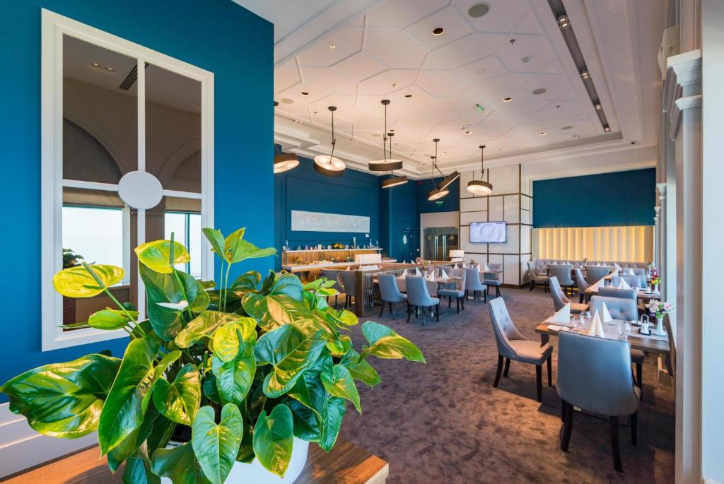 a restaurant with blue walls and tables and a plant at International Hotel Casino & Tower Suites in Golden Sands