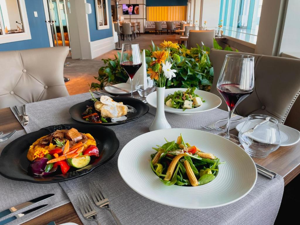 a table with plates of food and wine glasses at International Hotel Casino & Tower Suites in Golden Sands