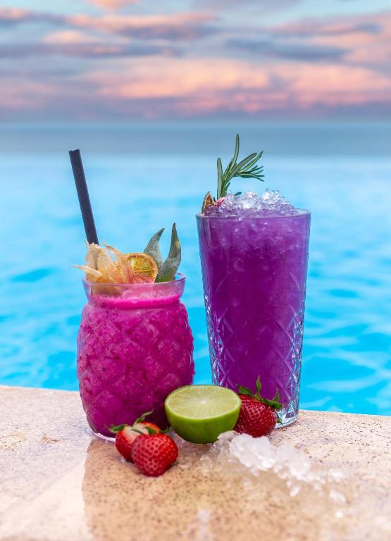 two cocktails with strawberries and limes next to a pool at International Hotel Casino & Tower Suites in Golden Sands