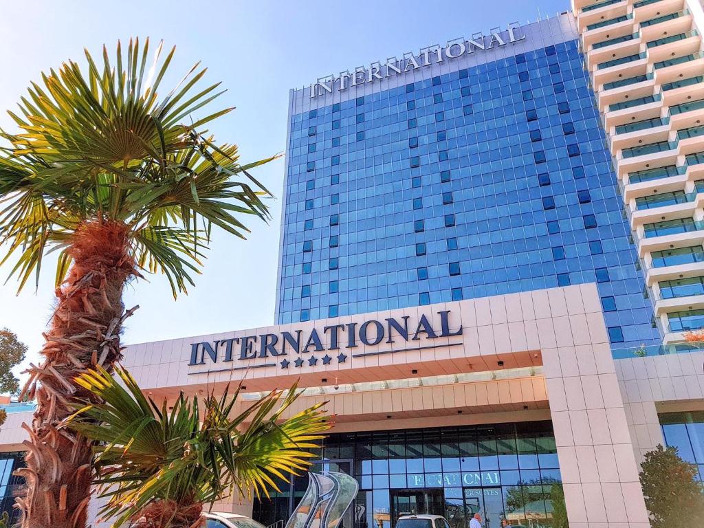 a tall building with a palm tree in front of it at International Hotel Casino & Tower Suites in Golden Sands