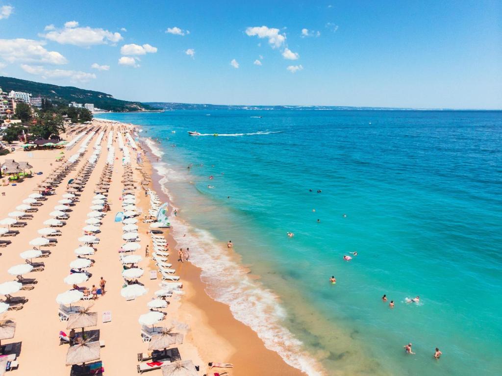 a beach with umbrellas and people in the water at International Hotel Casino & Tower Suites in Golden Sands