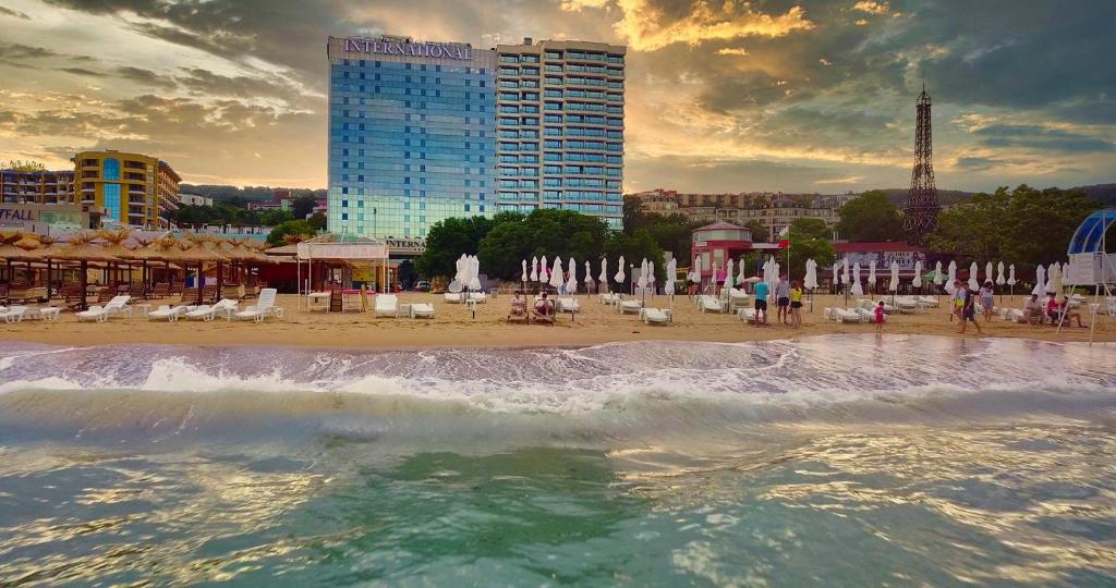 a beach with chairs and umbrellas and a building at International Hotel Casino & Tower Suites in Golden Sands