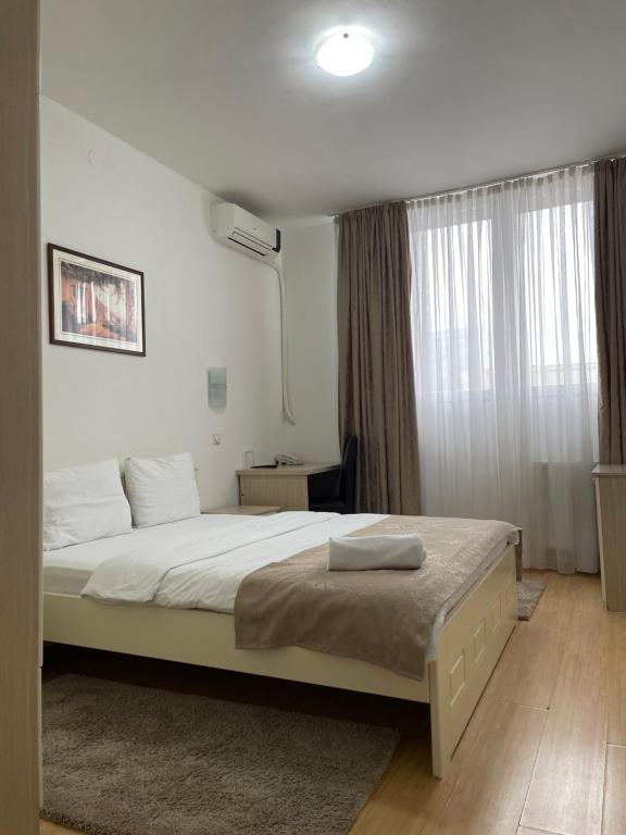een slaapkamer met een groot bed en een raam bij Garni Hotel Hamburg in Zaječar