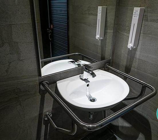 a white sink in a bathroom with a mirror at Taipei Discover Hostel in Taipei