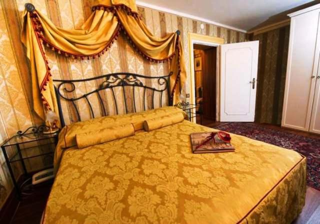 a bedroom with a large yellow bed with a tray on it at Locanda Antico Fiore in Venice