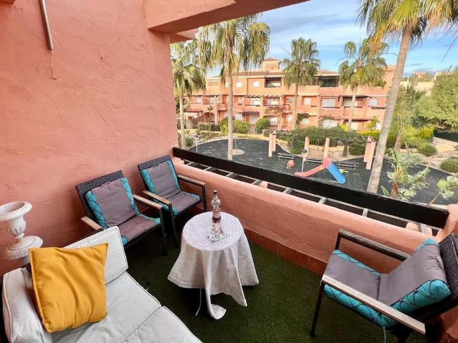 einen Balkon mit Stühlen und einem Tisch mit Poolblick in der Unterkunft Ático 3 dormitorios in Vera