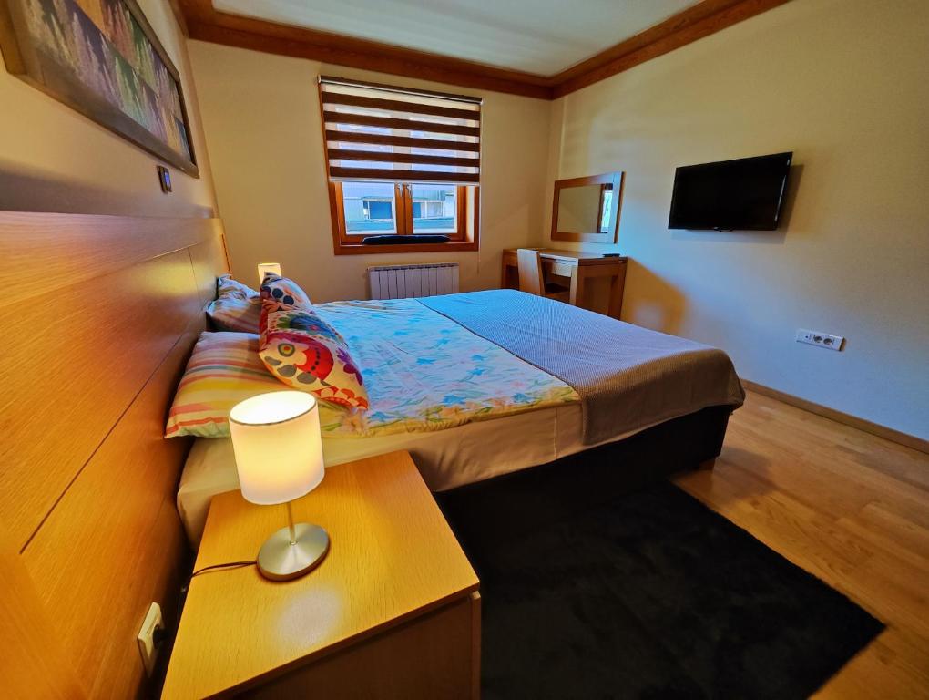 a bedroom with a bed and a table with a lamp at Vučko Apartment 107 Jahorina in Jahorina